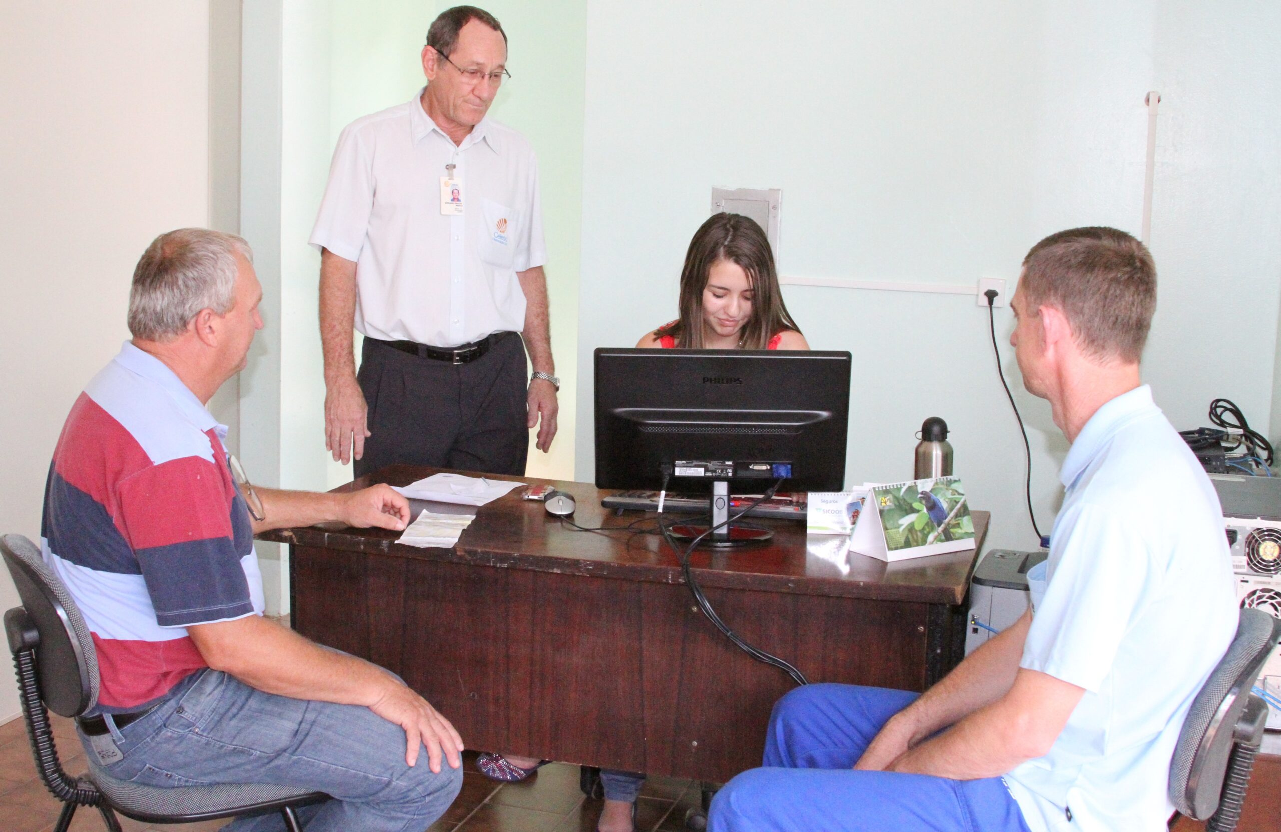 Gerente Adriano (em pé) e estagiária Lauren atendem os primeiros clientes do escritório em Saudades